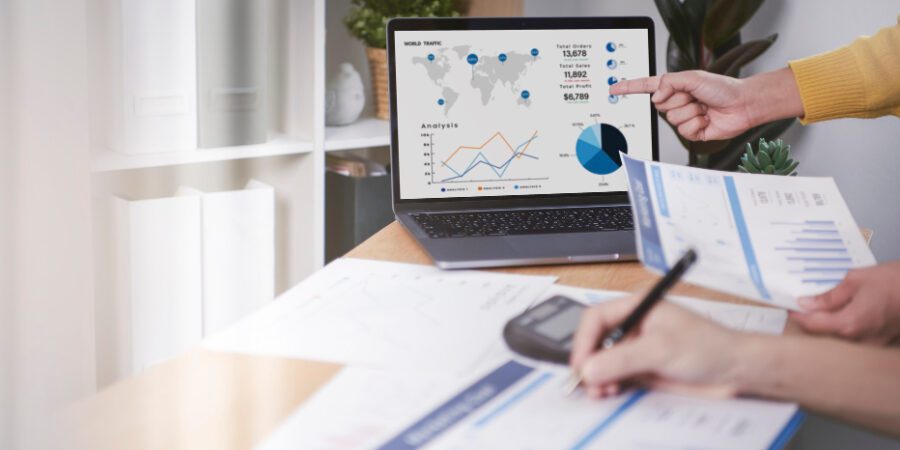 Business finance reporting papers and laptop showing charts and graphs representing Azure spend optimisation