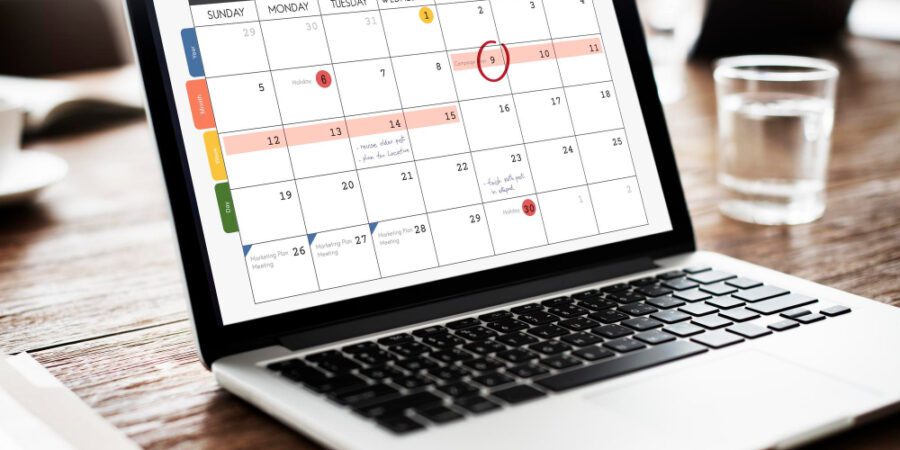 Laptop with calendar planning on the screen to represent Outlook scheduling poll