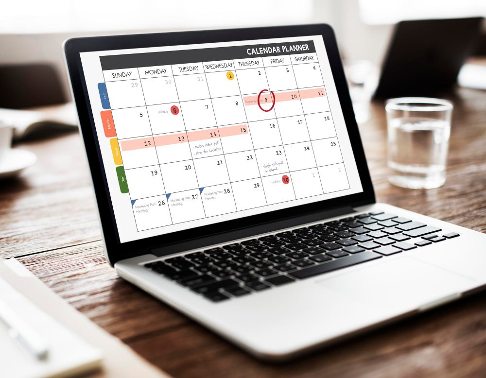 Laptop with calendar planning on the screen to represent Outlook scheduling poll