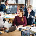 Colleagues in an office setting working happily together to represent SharePoint Modern Workplace